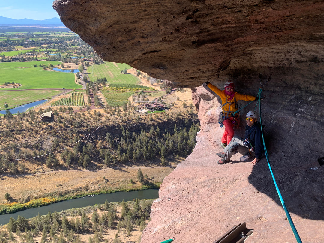 Two climbers in a cave-like area known as the Monkey's mouth, high above the ground at Smith Rock.