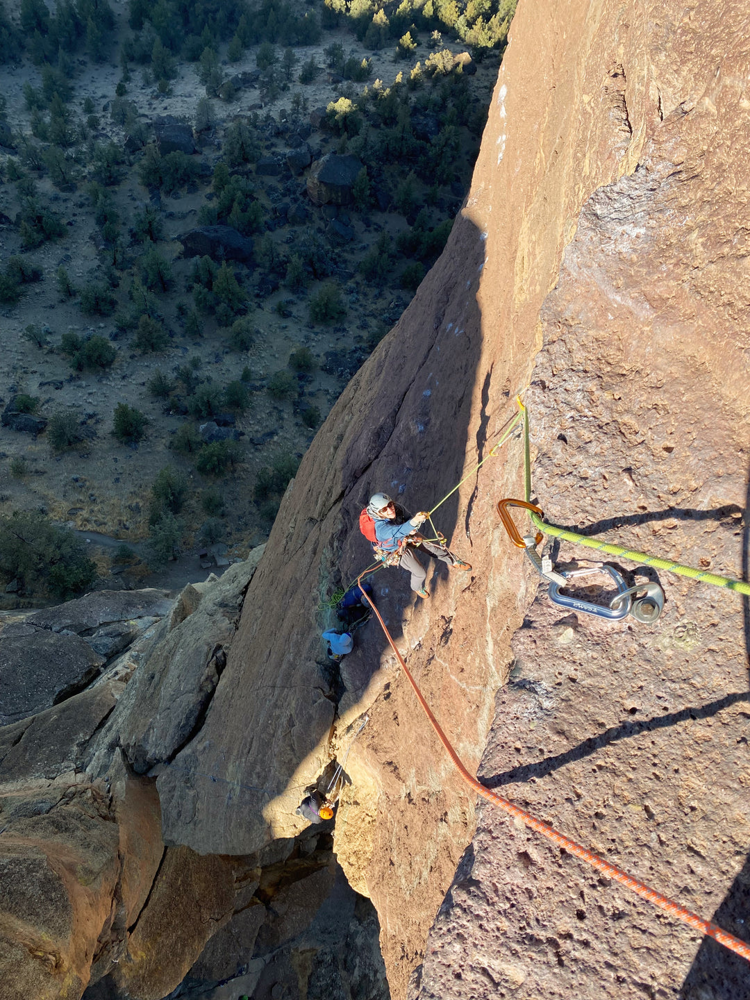 A climber uses aiders and an ascender to help her climb a short vertical rock section on a feature known as Monkey Face.