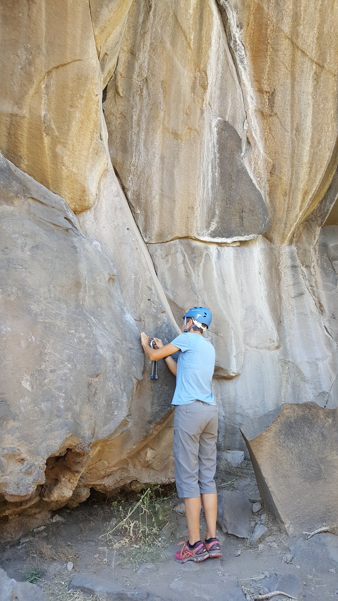 A student practices placing passive protection while learning the fundamentals of traditional trad climbing.